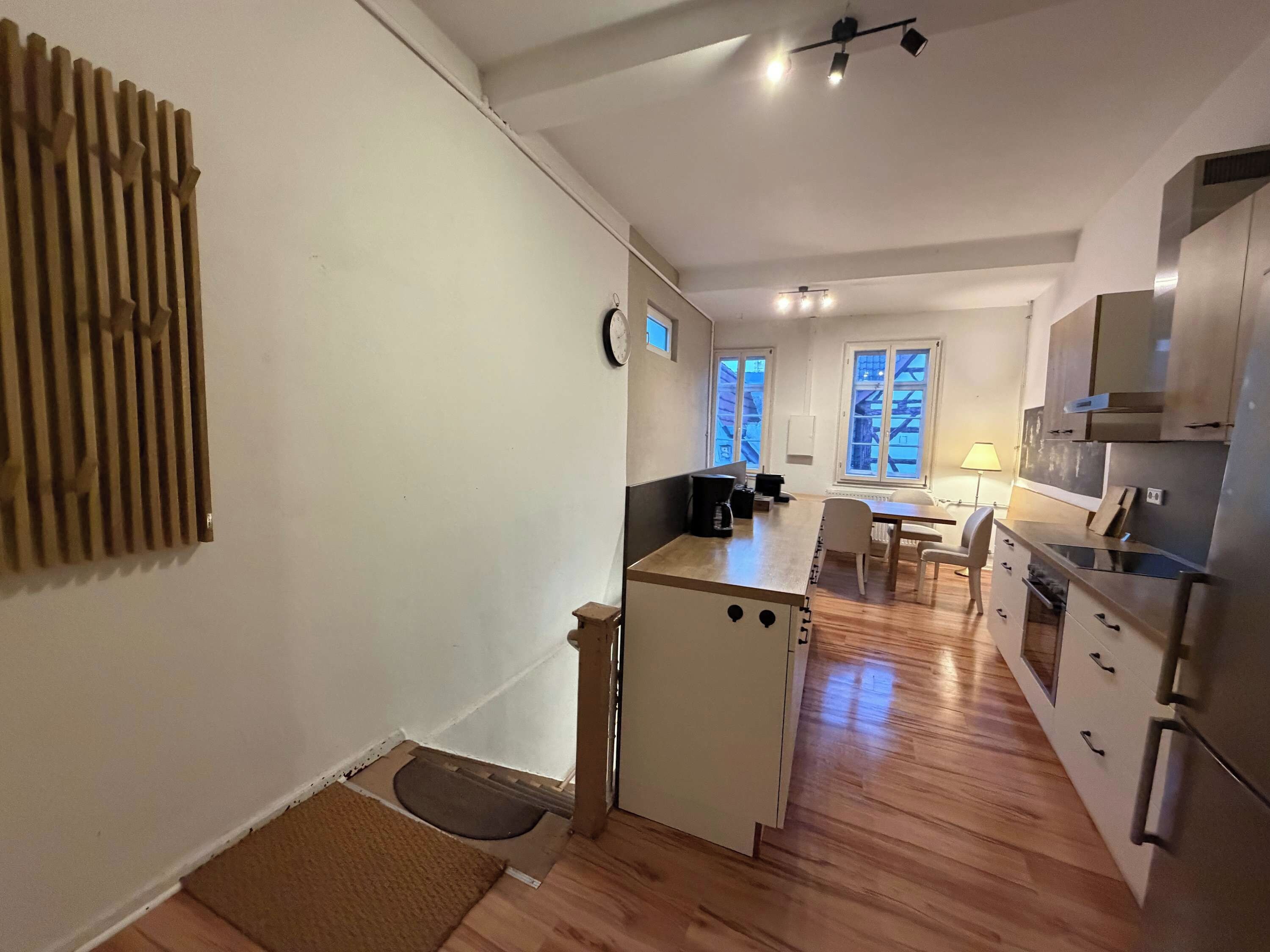 A compact kitchen with a refrigerator, stove, and a dining area with a table and chairs.