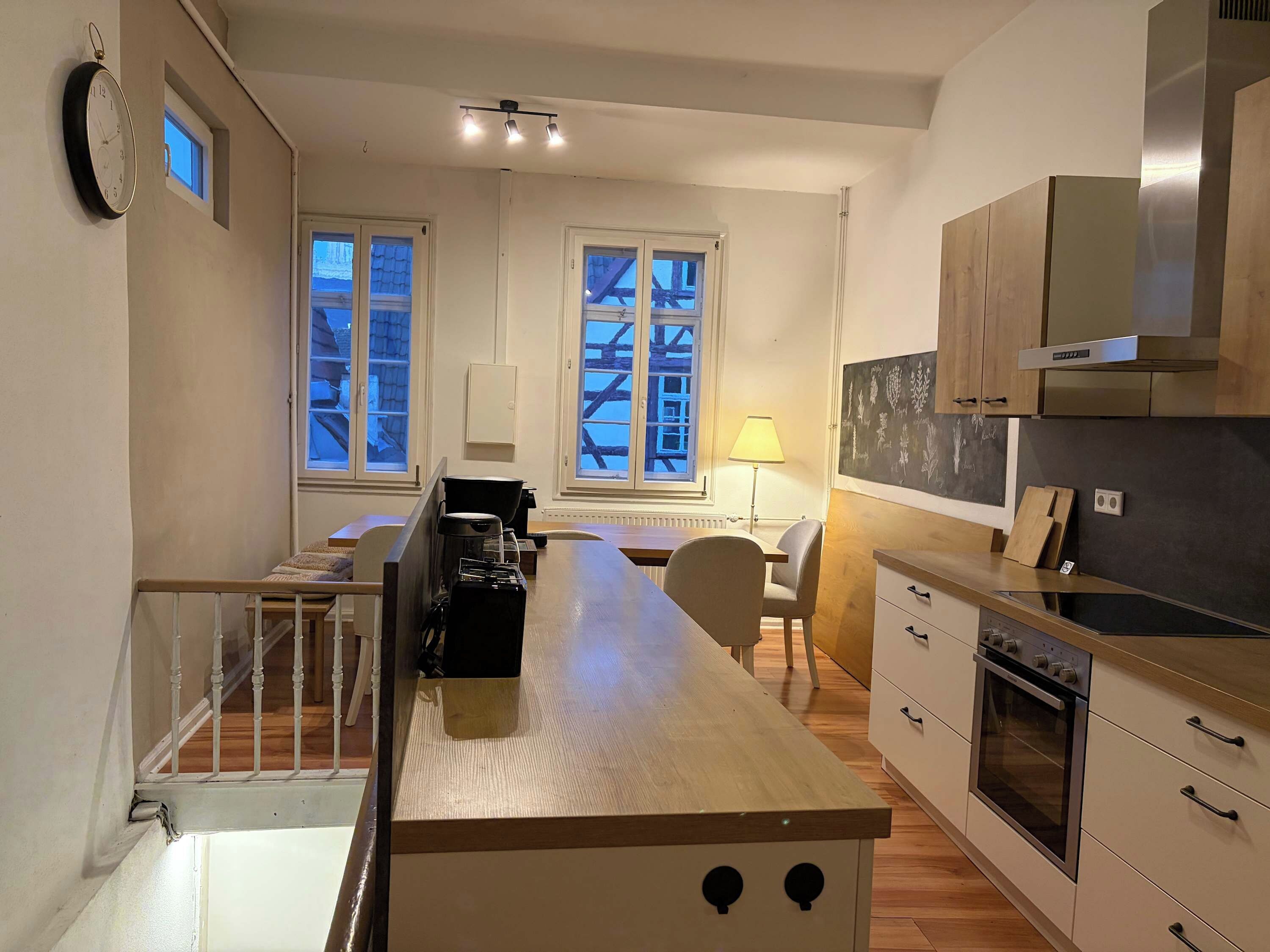 Een moderne keuken met een centraal eiland, houten kastjes en een inbouwoven.