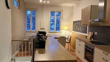 Een moderne keuken met een centraal eiland, houten kastjes en een inbouwoven.