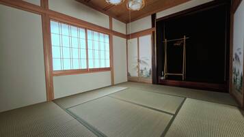 A traditional Japanese room with tatami flooring, sliding doors, and a view of the outdoors.
