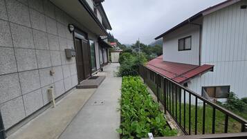 Un étroit sentier bordé de bâtiments aux murs recouverts de carreaux et délimité par une clôture en métal.