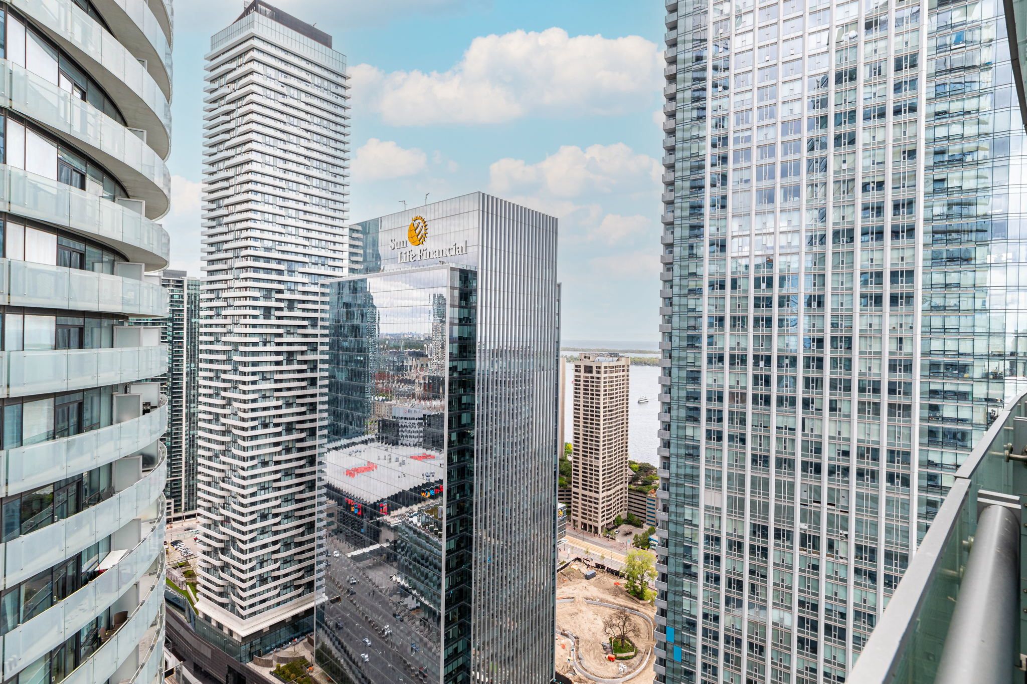 A high-rise building with a prominent logo, surrounded by other modern skyscrapers.