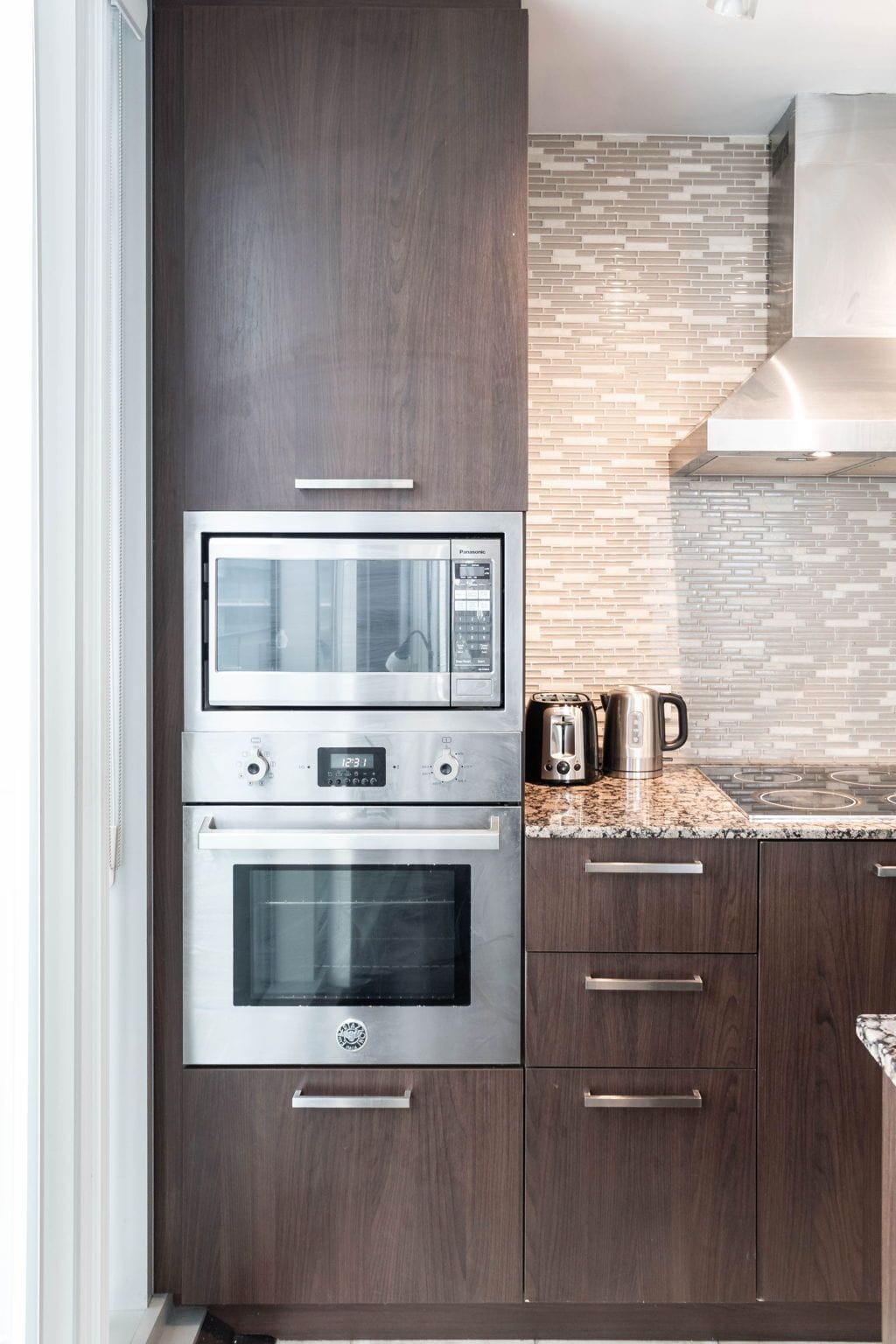A kitchen with a built-in microwave, oven, and toaster.