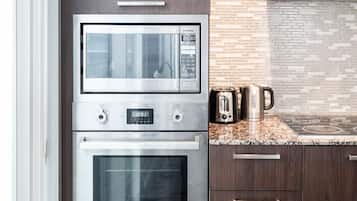 A kitchen with a built-in microwave, oven, and toaster.