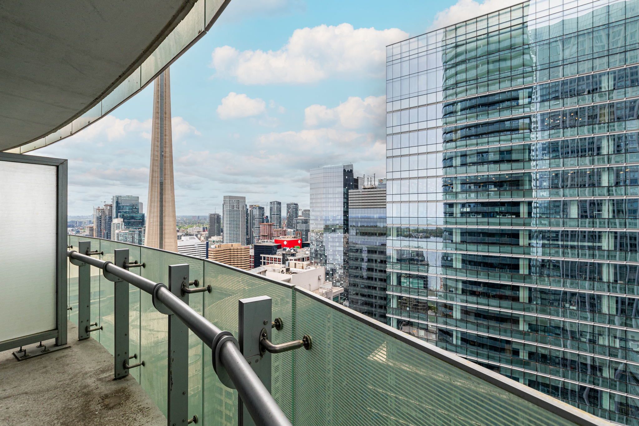 A high-rise building with a glass facade overlooking a cityscape.