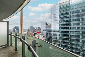 A high-rise building with a glass facade overlooking a cityscape. - Modern 2BR 1.5BA + Free Parking, CN Tower, Jays! (Toronto)
