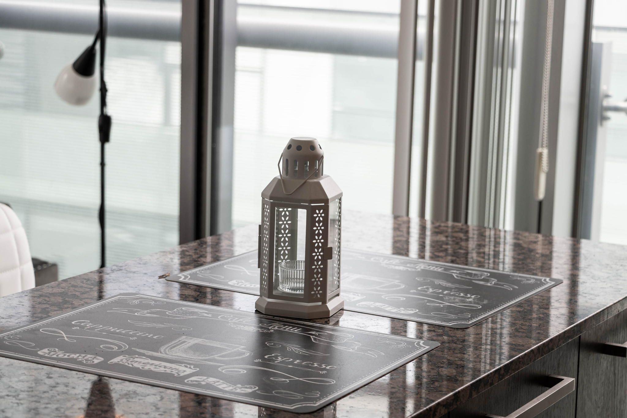 A table with a decorative lantern and a menu with coffee and espresso options.