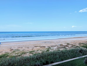 Een strand met heldere lucht en rustige zee.