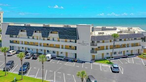A multi-story hotel with a parking lot in front, a beach view, and a sign indicating it is a resort. - Oceanfront Escape in Ormond Beach! (Ormond Beach)