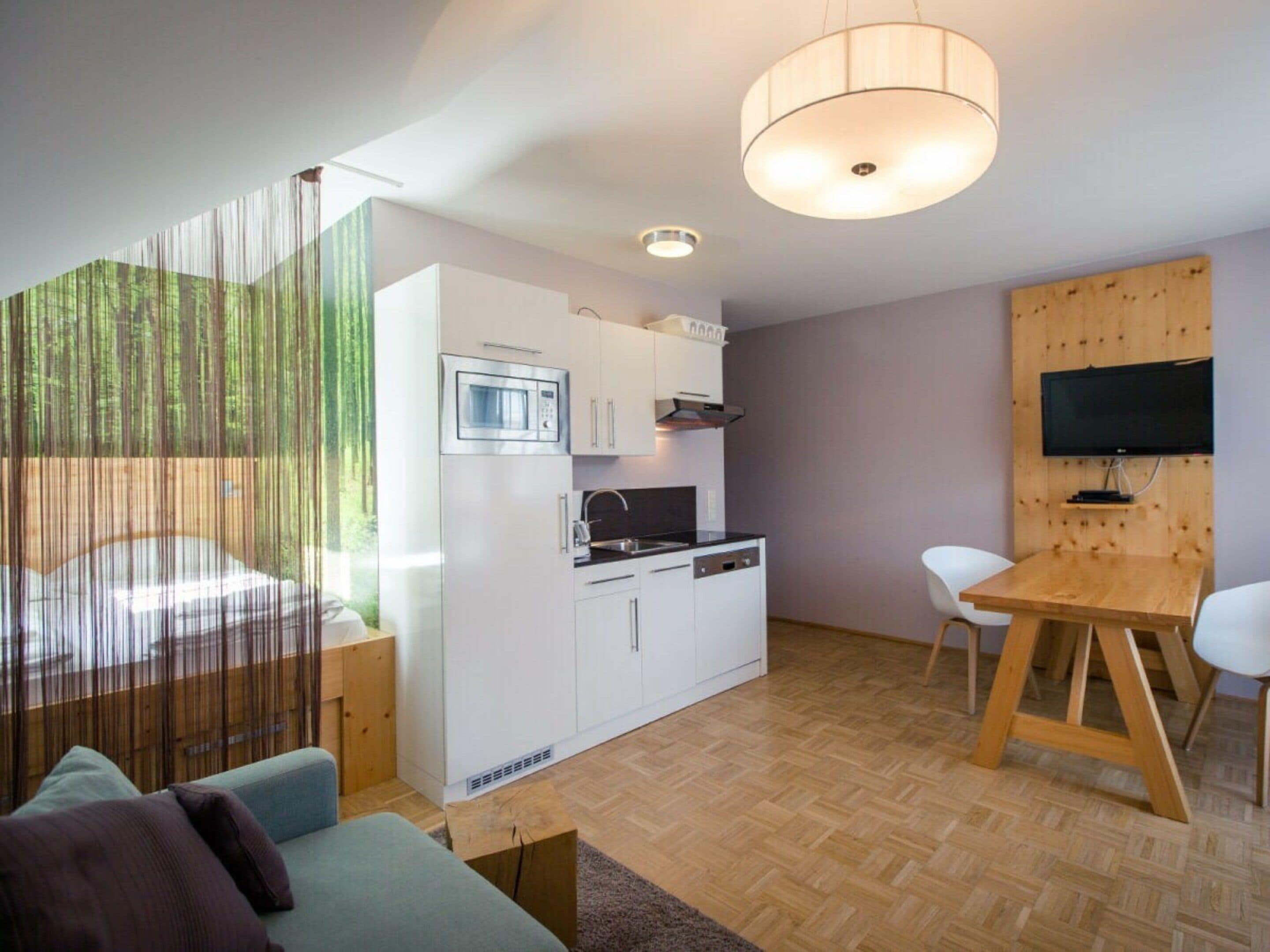 A compact living space with a kitchenette, a dining area, and a seating area.