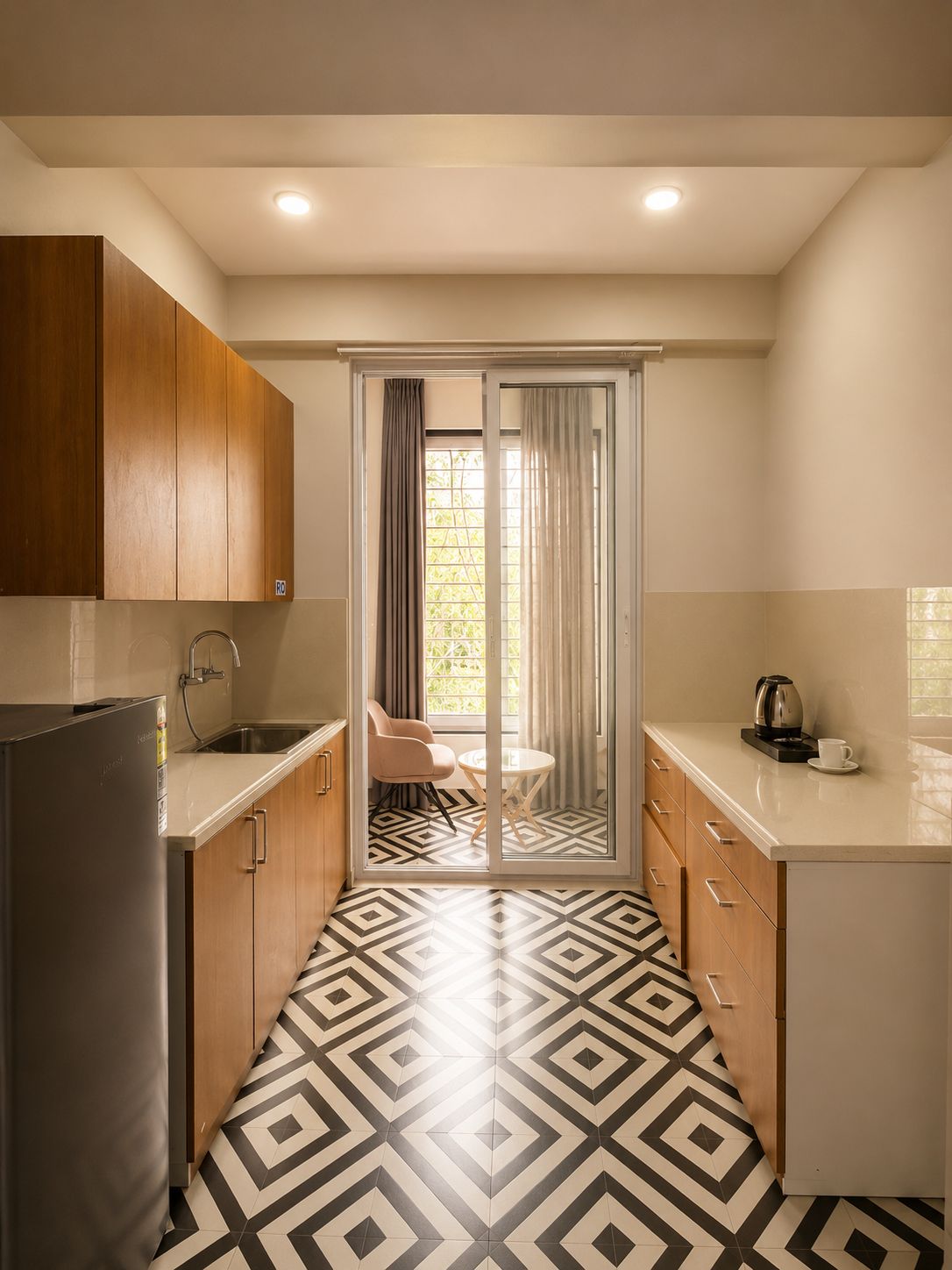 A compact kitchen with a refrigerator, sink, and a dining area with a table and chairs.