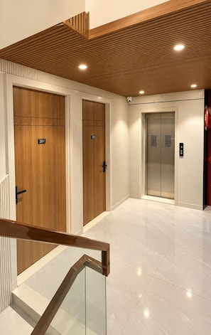 A modern elevator area with two elevators, each marked with a number.