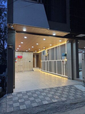 Une entrée moderne, avec un sol carrelé, un plafond en bois et un éclairage encastré.