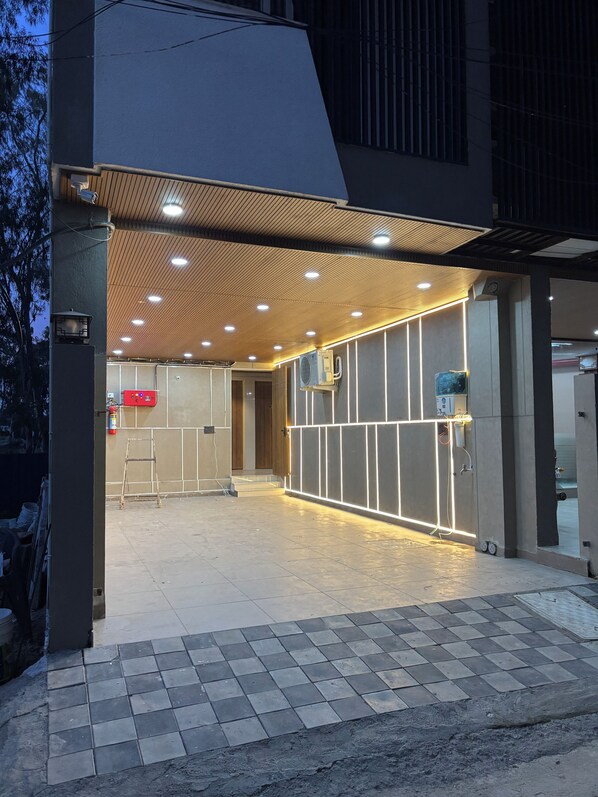 A modern building entrance with a tiled floor, a wooden ceiling, and recessed lighting.