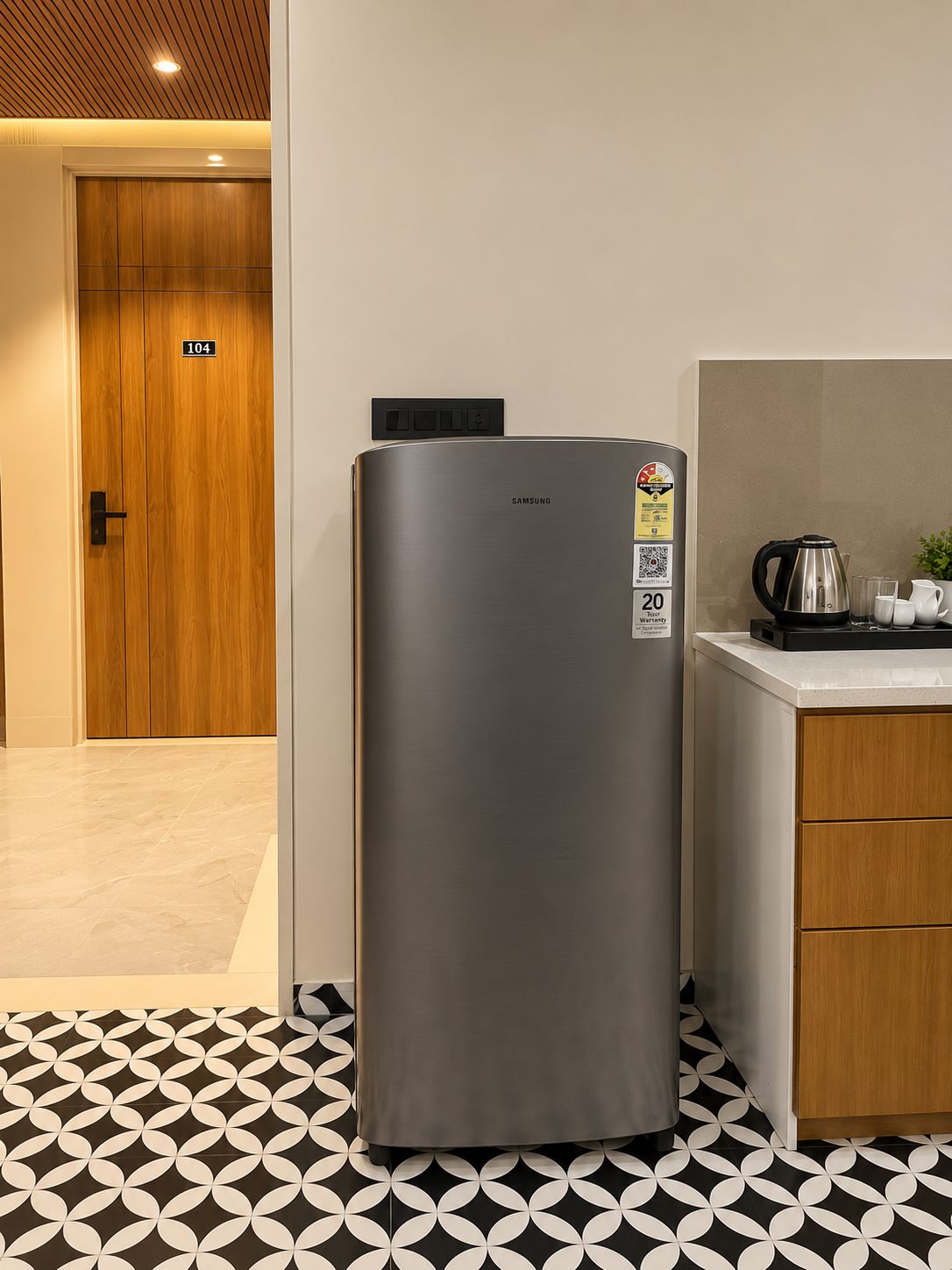 Una cocina moderna con un refrigerador de acero inoxidable, una puerta de madera y un piso con diseño.