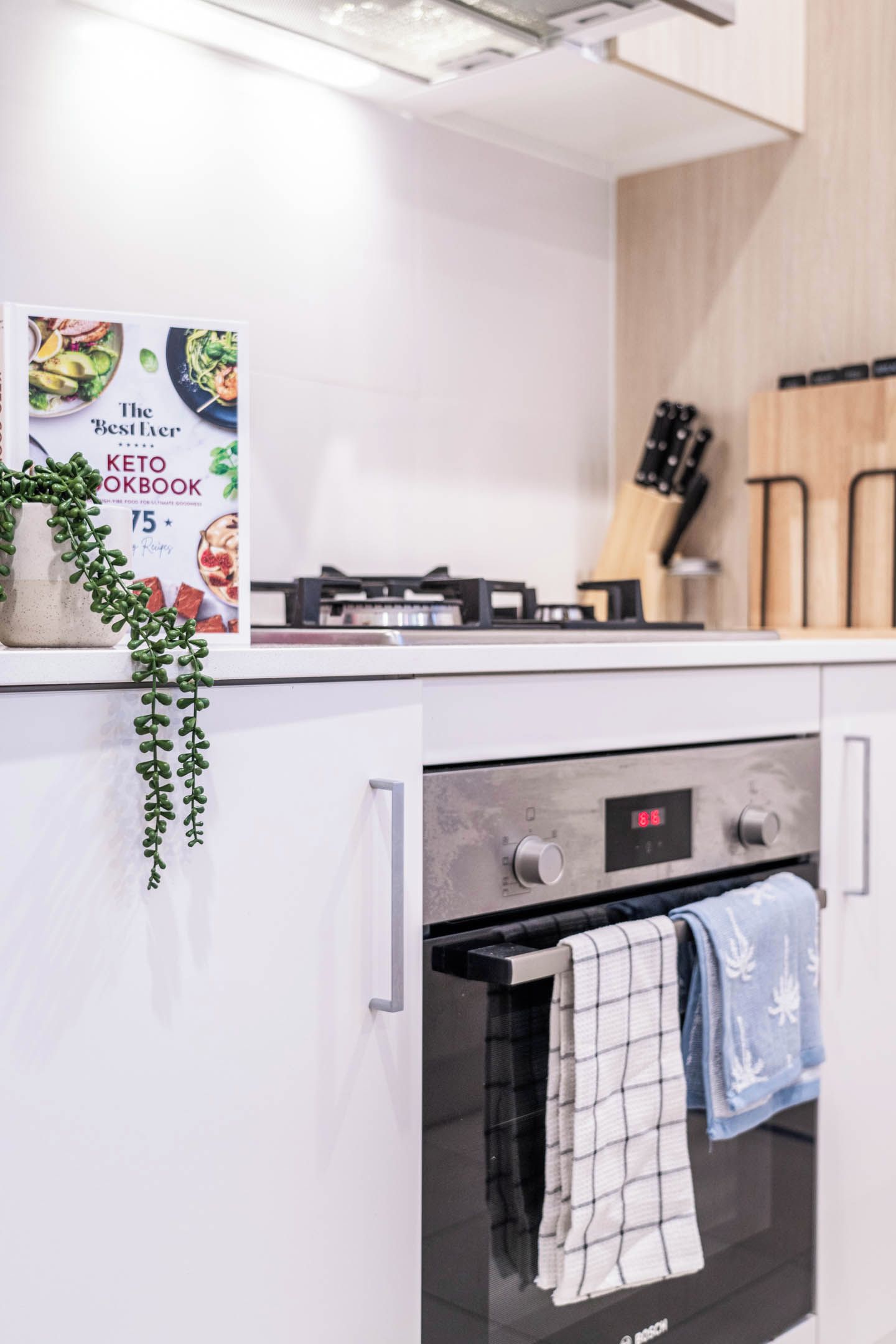 Une cuisine équipée d’un livre de recettes, d’une cuisinière et d’un four.