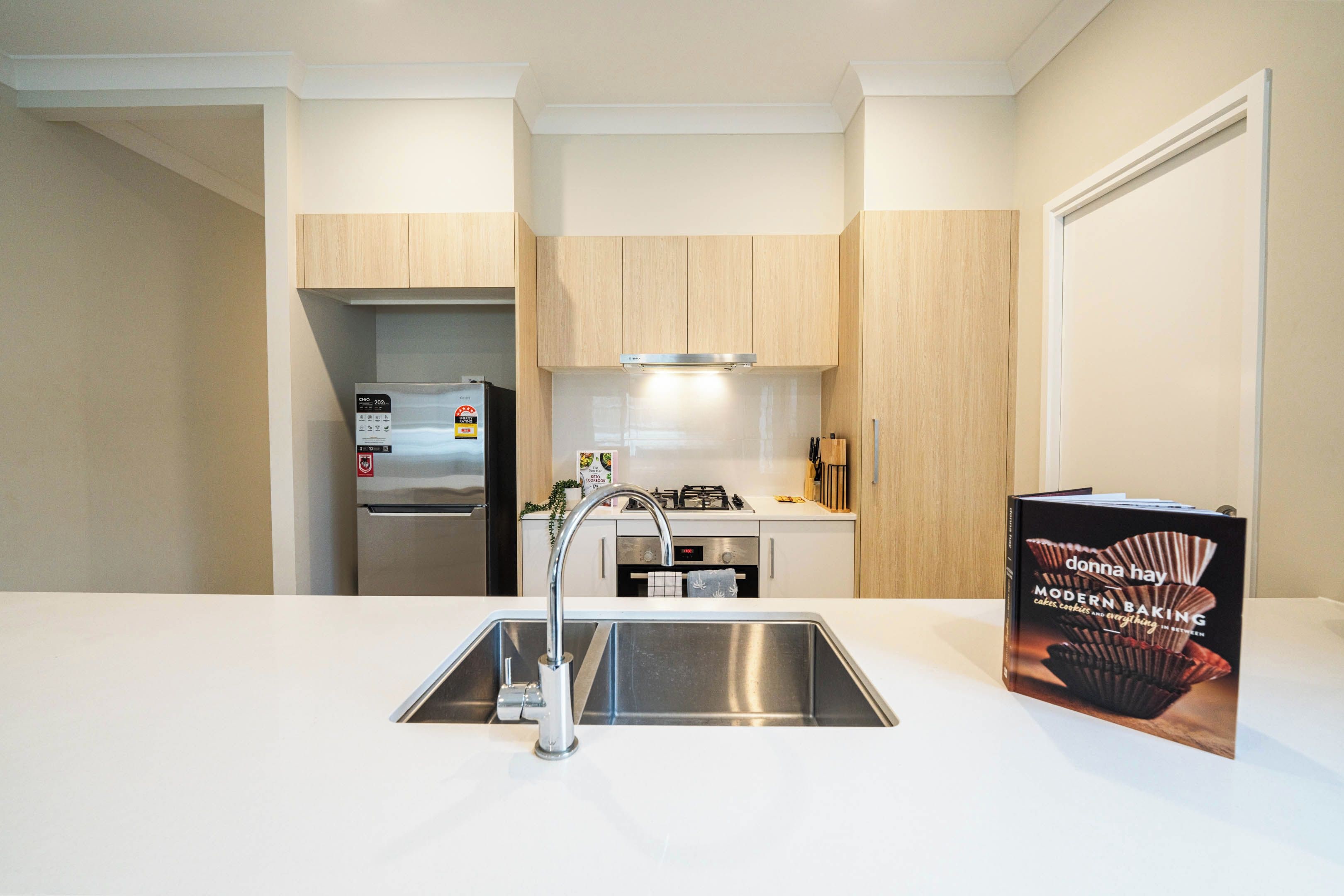 A modern kitchen with stainless steel appliances, a built-in oven, and a double sink.