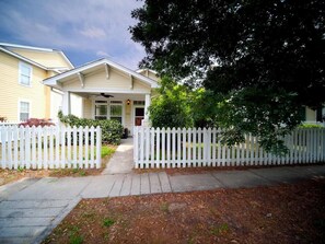 A residential house with a front porch, white picket fence, and a driveway. - Barb’s Stylish Digs: Modern Home+ Prime Location! (North Charleston)