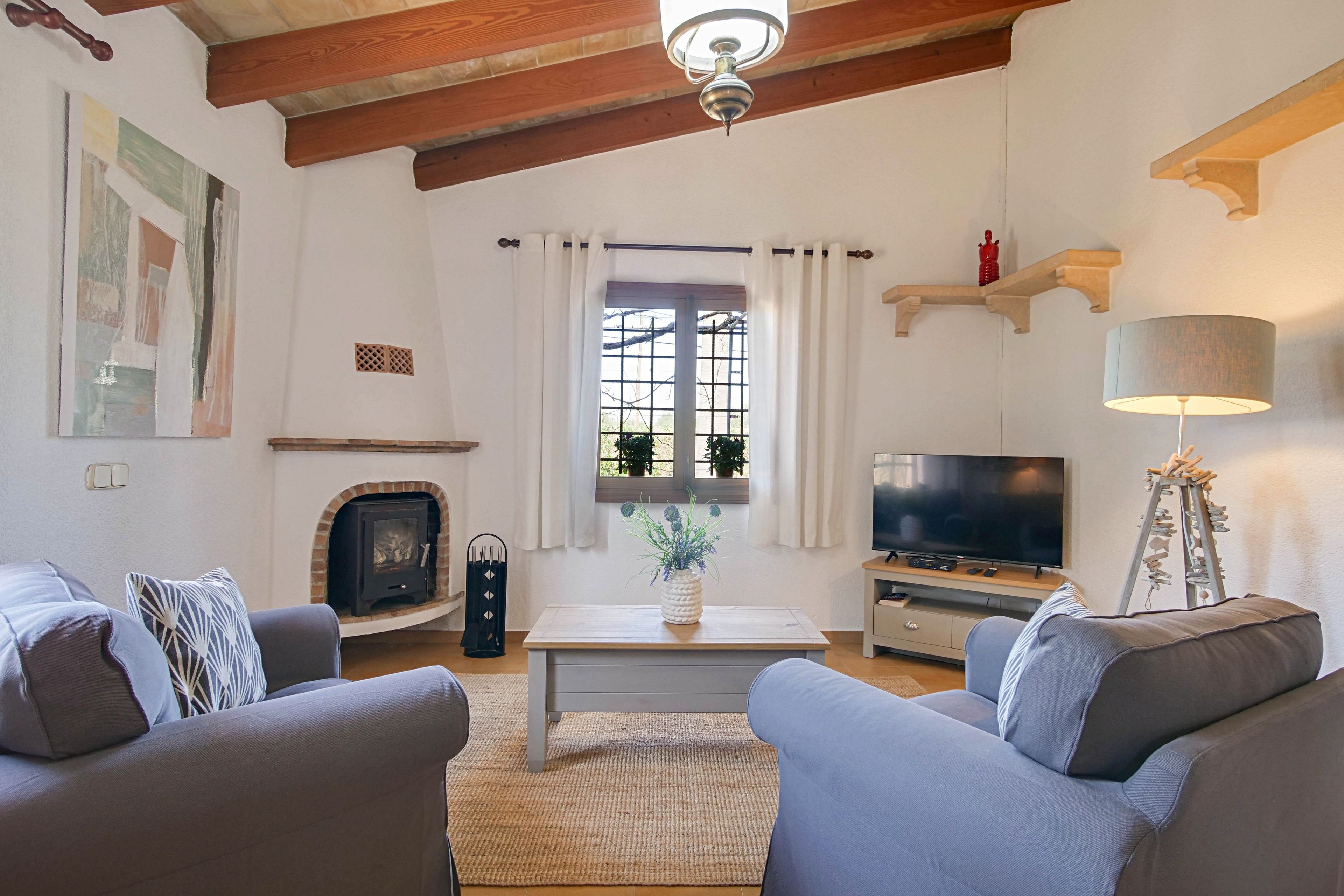 A living room with a fireplace, a television, and a sofa.