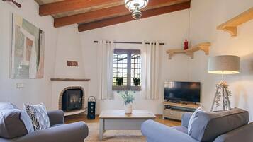 A living room with a fireplace, a television, and a sofa.