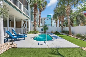 A pool area with a small pool, lounge chairs, and palm trees. - Steps to Beach + Private Pool | Sleeps 12 | 5BR (Murrells Inlet)