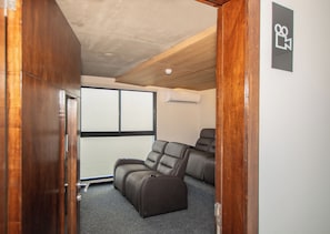 A room with a ceiling fan, a window with blinds, and a pair of leather recliners. - Corporate Stays First del Sol - 208 (Asunción)