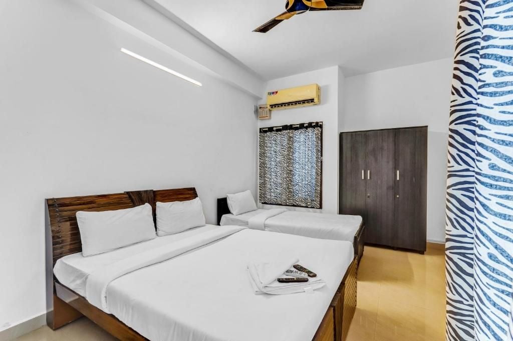 A hotel room with a large bed, a wardrobe, and a ceiling fan.