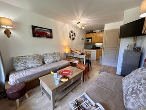 A compact living space with a sofa, coffee table, and a dining area. - Cozy apartment, parking - 4 guests (Vars)