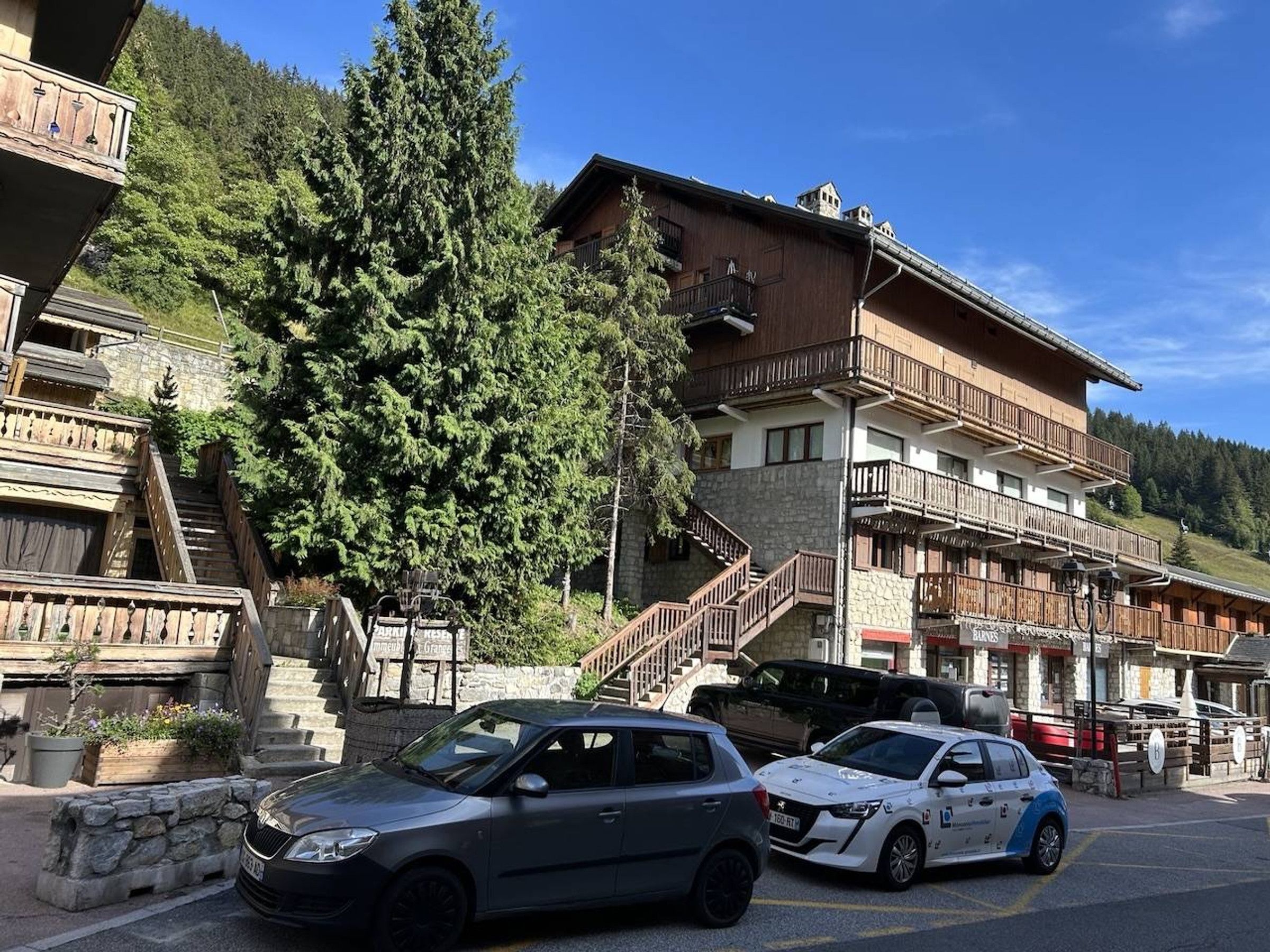 A hotel with a stone facade, wooden balconies, and a staircase leading to the upper floors.