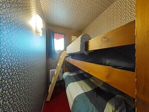 A bunk bed room with a patterned wall, a window with a curtain, and a ladder. - Studio cabin with slope view - 4 guests (Le Grand-Bornand)