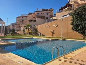 A swimming pool with a clear blue water surface, surrounded by a tiled deck. - Modern apartment, mountain views - 4 guests (Aguilas)