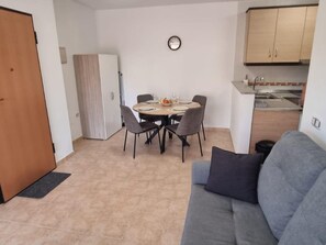 A compact living space with a dining area, kitchenette, and a sofa. - Modern apartment, mountain views - 4 guests (Aguilas)