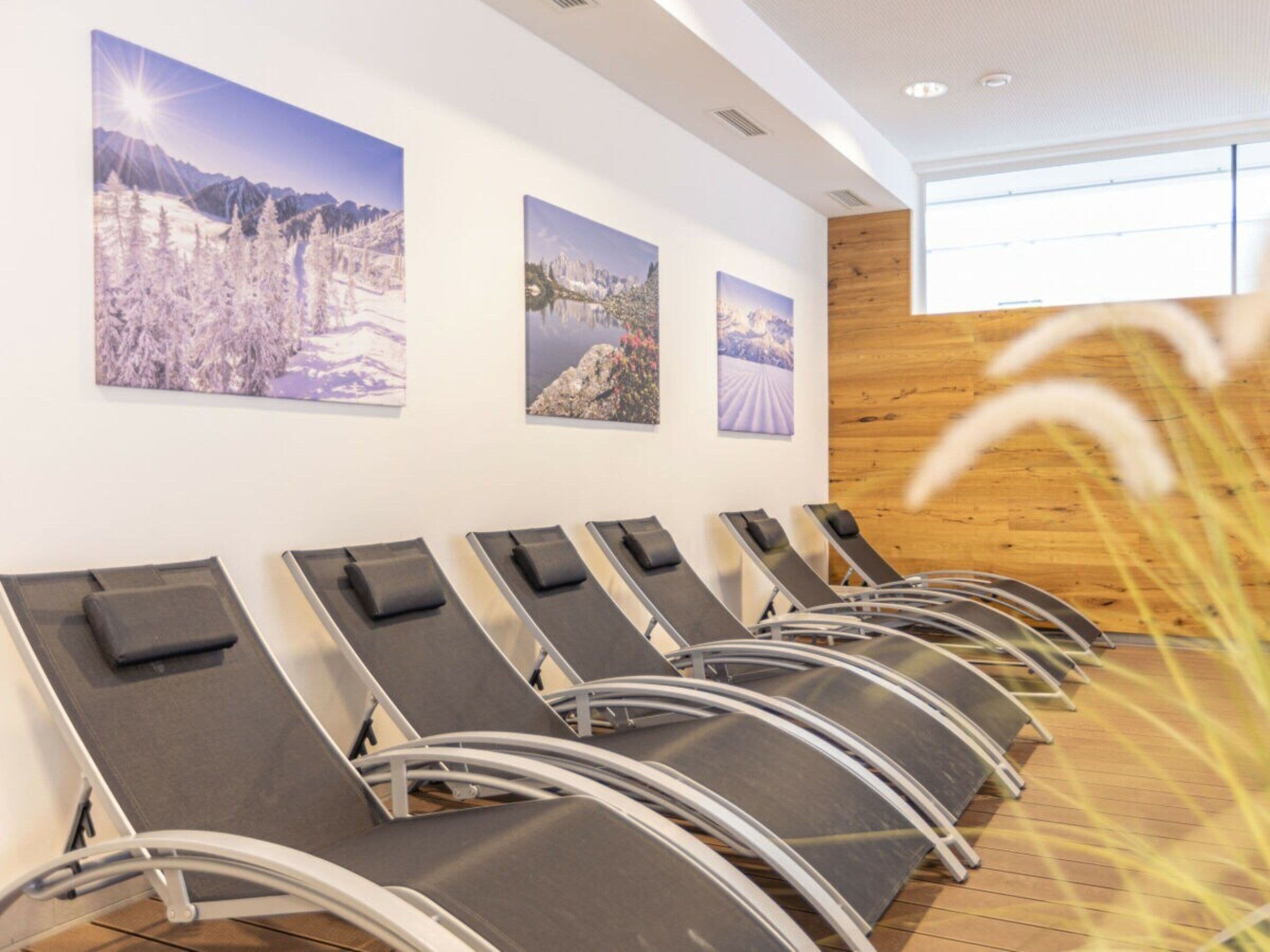 A waiting area with reclining chairs and three framed landscape photographs on the wall.