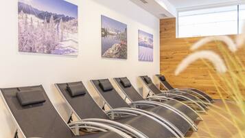 A waiting area with reclining chairs and three framed landscape photographs on the wall.
