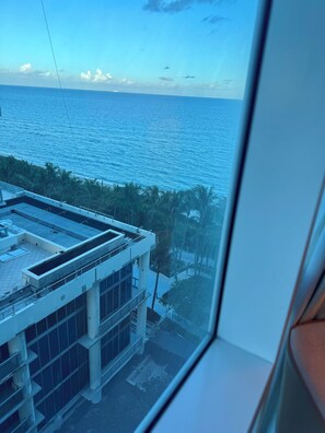 A view of a building with a flat roof and a large window overlooking a body of water. - Ultimate 2BR Oceanfront Carillon Beach Getaway (Miami Beach)
