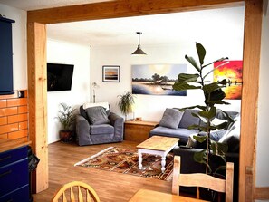 A cozy living room with a sofa, armchair, and a coffee table. - Ty Marlyn, St Davids (Haverfordwest)