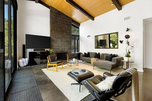 Un salon moderne avec un téléviseur à écran plat, une cheminée, un canapé et une table basse.