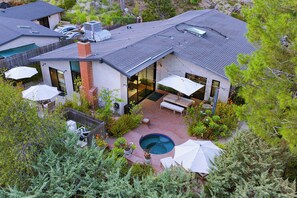 Une maison moderne dotée d’une piscine, de mobilier d’extérieur et d’un patio couvert.