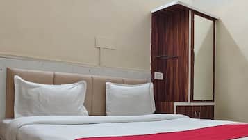 A standard hotel room with a bed, a wardrobe, and a mirror.