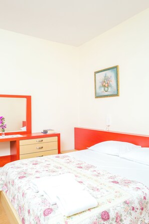 A bedroom with a bed, a dresser, a mirror, and a painting on the wall. - Twin Villa 1 Tragjas,  Nature & River near Vlora (Tragjas)