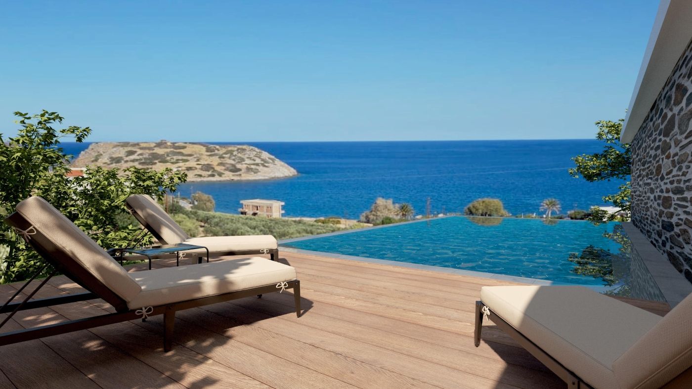 A poolside area with lounge chairs and a view of the sea.
