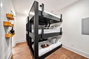 A bunk bed with a wooden ladder, a shelf with a plant, and a bedside table with a candle. - Walk to Hattie B s - East Nashville Sleeps 12 (Nashville)