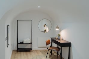 A room with a desk, chair, and a hanging light fixture. - Joivy Vaults Studios & Apartments (Edinburgh)