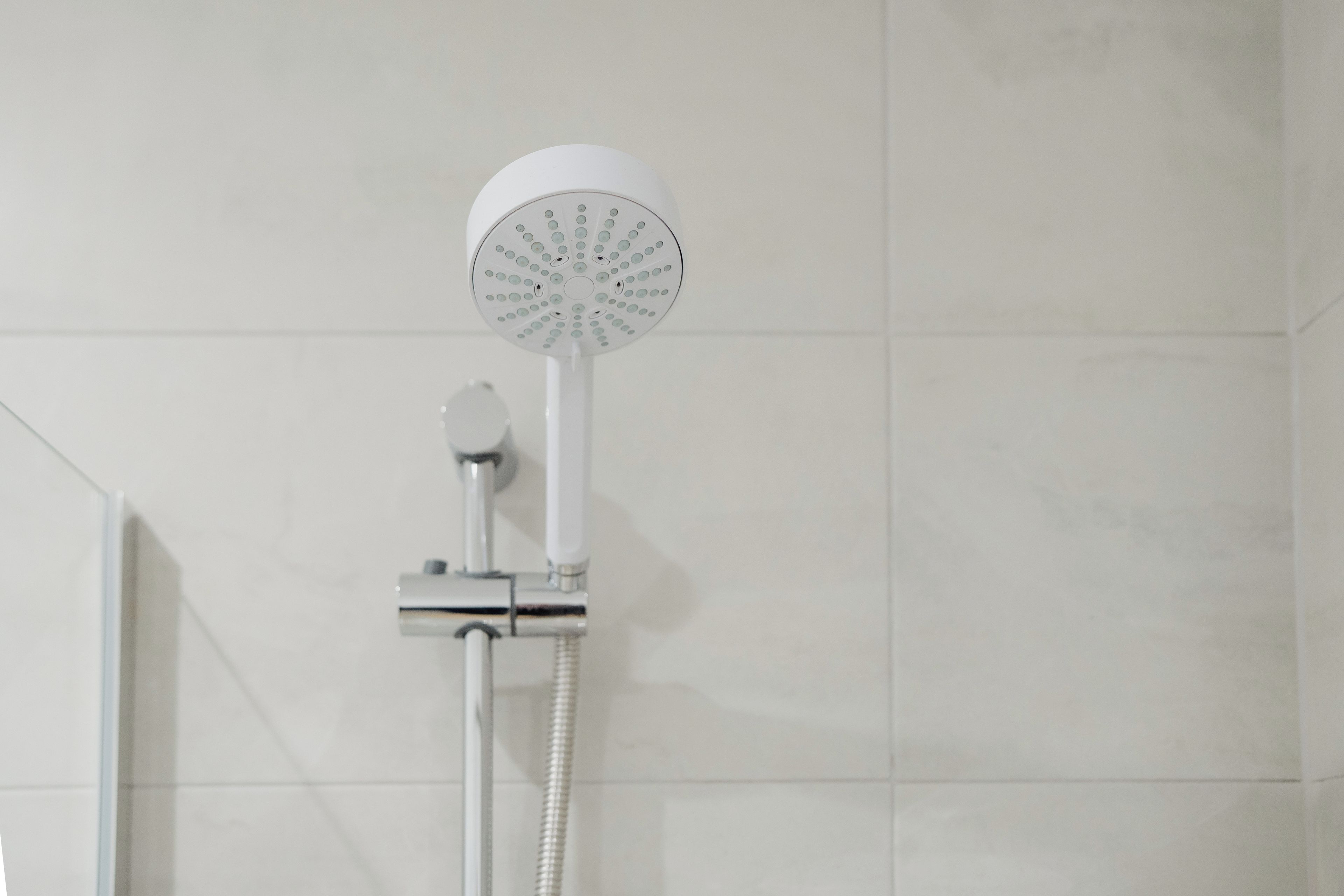 Un pommeau de douche de forme circulaire, muni d’un flexible.