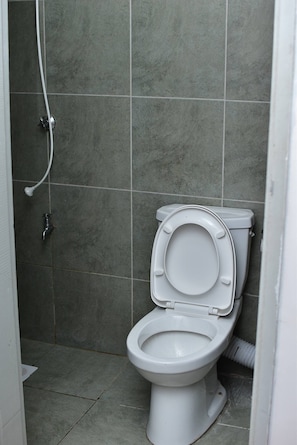 A bathroom with a toilet, a shower, and a wall-mounted sink. - The Sunset Nest - Serene 1-bedroom apartment perfect for relaxing stay (Kiambu Province)