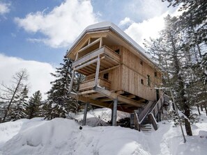 A wooden cabin with a balcony, surrounded by snow and trees. - Cabin in Turrach With Sauna and Balcony (Stadl-Predlitz)