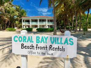 A sign for Coral Bay Villas indicating beach front rentals with an office to the back. - Lionfish Suite | Adults-Only Beachfront Escape (San Pedro Town)
