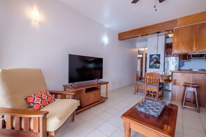 Ein Wohnzimmer mit Fernseher, Sofa und Holzmöbeln.