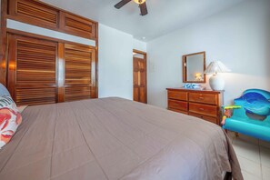 Ein Schlafzimmer mit einem Bett, einem Holzschrank, einem Schminktisch und einem Spiegel.