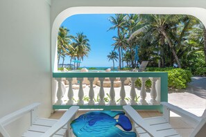 Ein Balkon mit Blick auf Strand und Palmen.